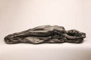 Entitled L’Abandon, this is a photograph depicting a one-quarter life-size bronze sculpture of a laying female figure, created by sculptor Blake Ward