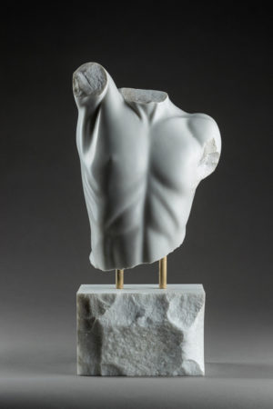 Entitled Mithras, this is a photograph depicting a one-quarter life-size marble sculpture of a partial male torso, created by sculptor Blake Ward